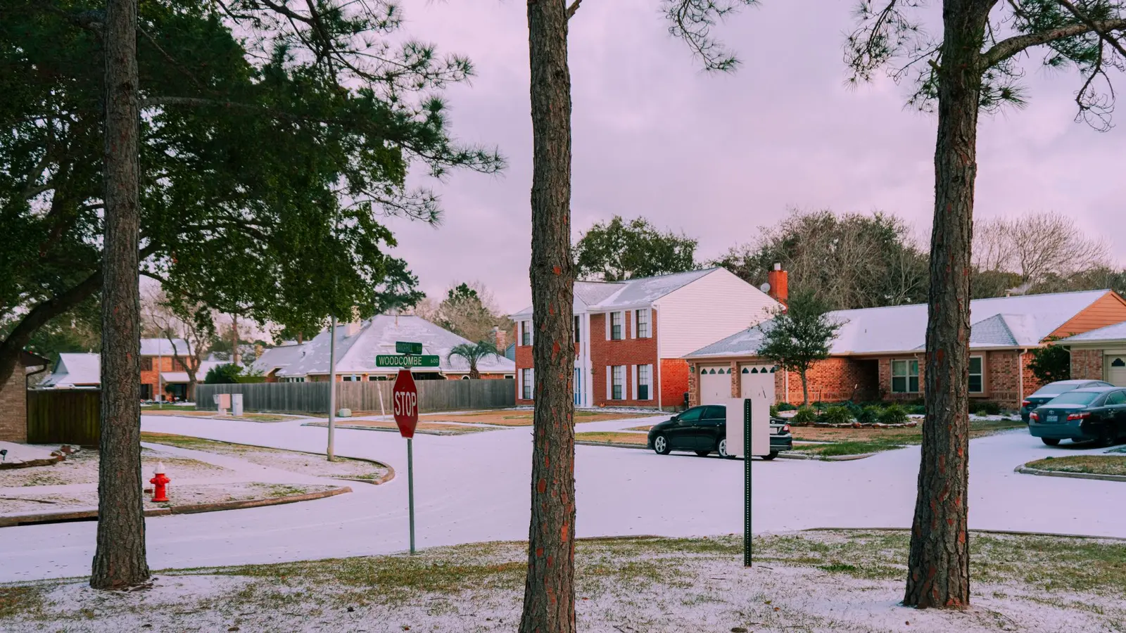 Light snow on a residential street corner with a stop sign