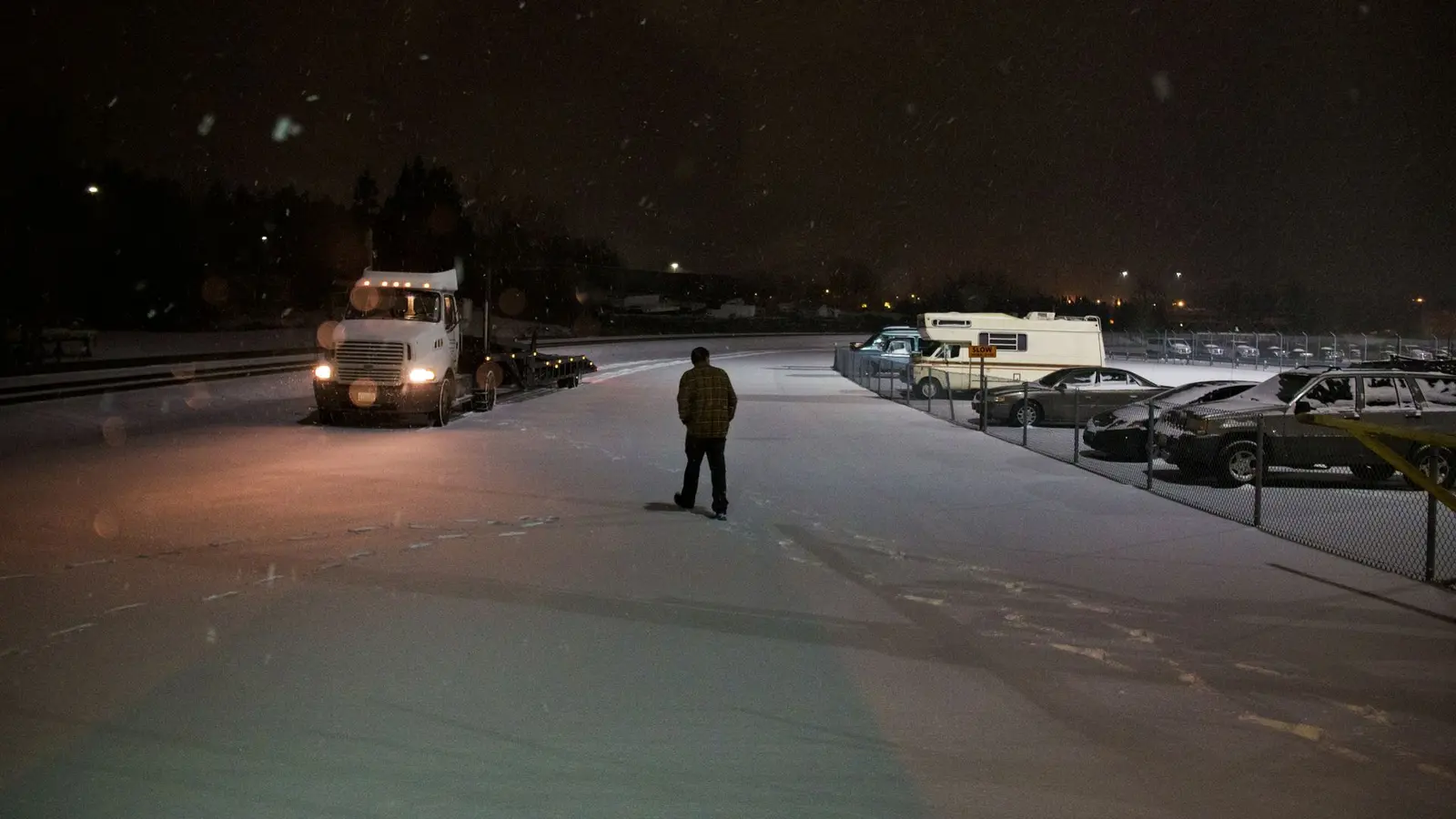 Pickup truck in a snow-covered parking lot at night