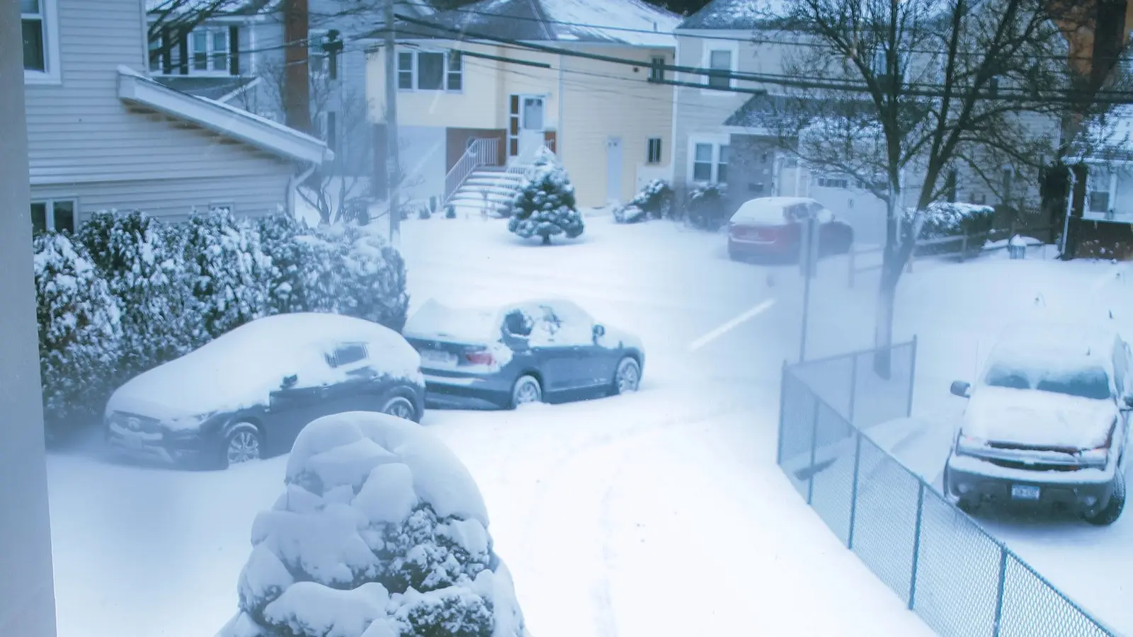 Person clearing a long residential driveway with a snowblower after a snowfall