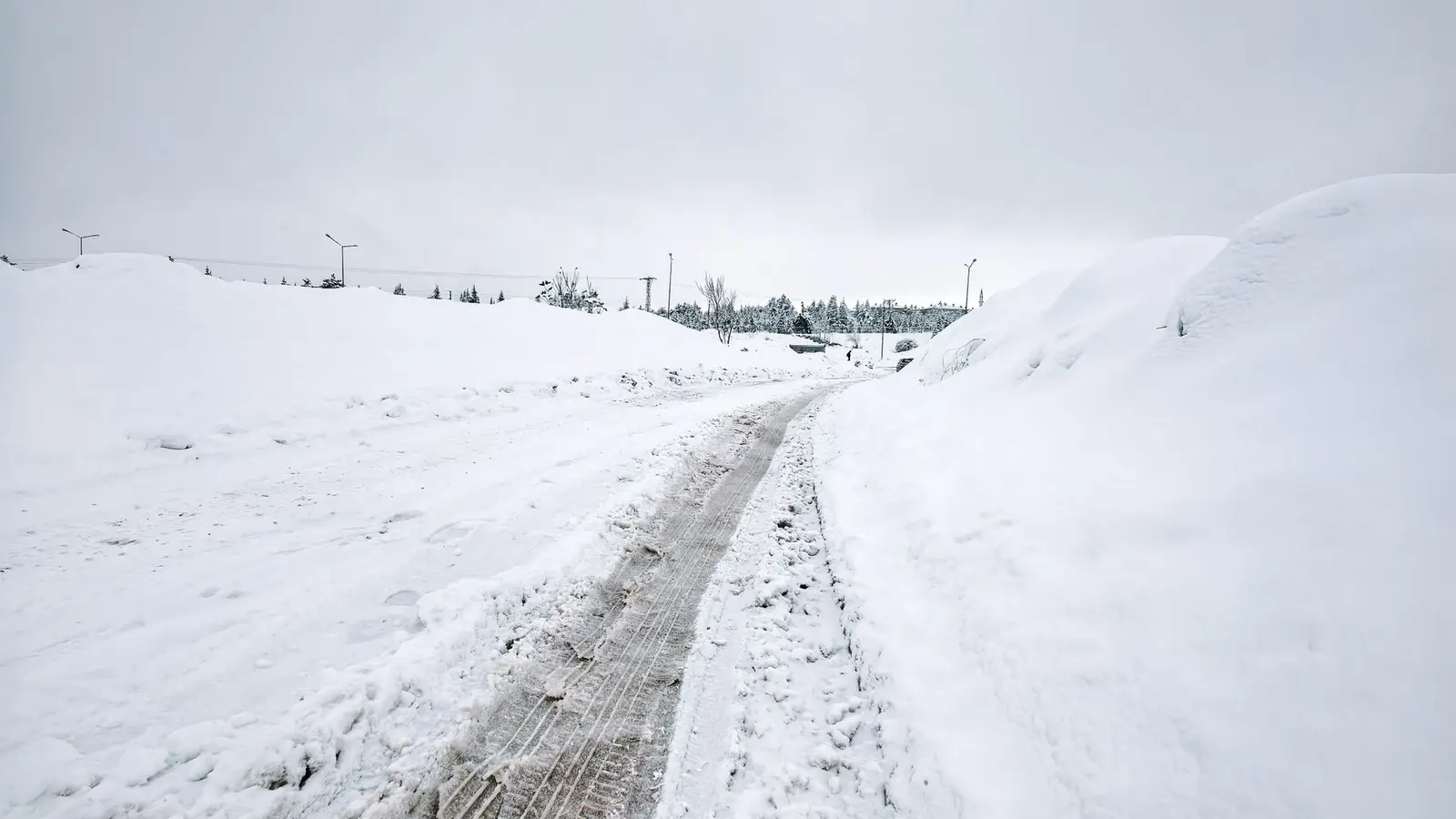 Cleared path running along a snow-covered open field