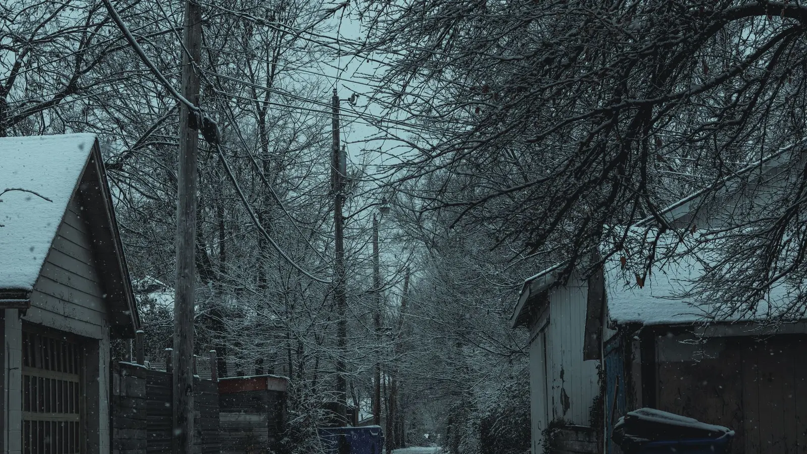 Snowy alley between garages and houses after a storm